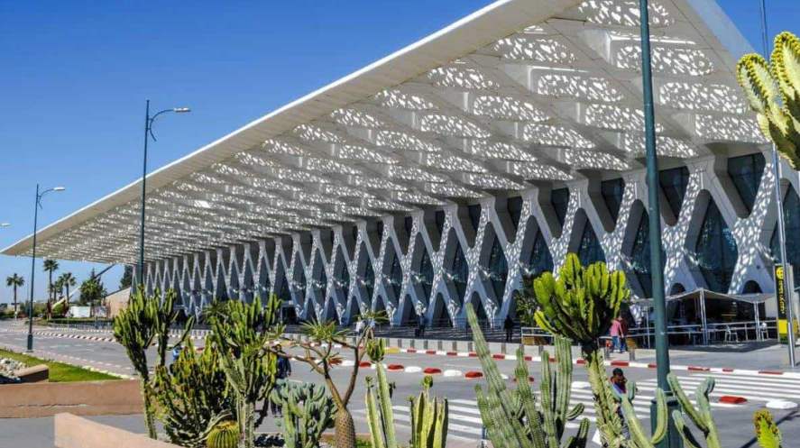 Marrakech Menara Airport terminal exterior with travelers arriving and taxis waiting — airport transfer guide